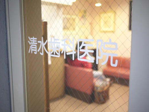 清水歯科医院の名前が入った入口のガラス扉